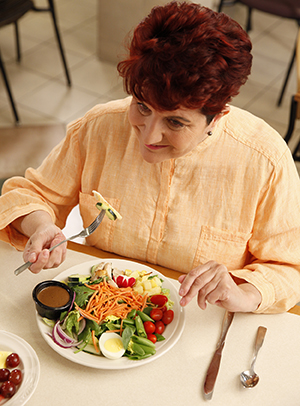 Mujer comiendo una ensalada.